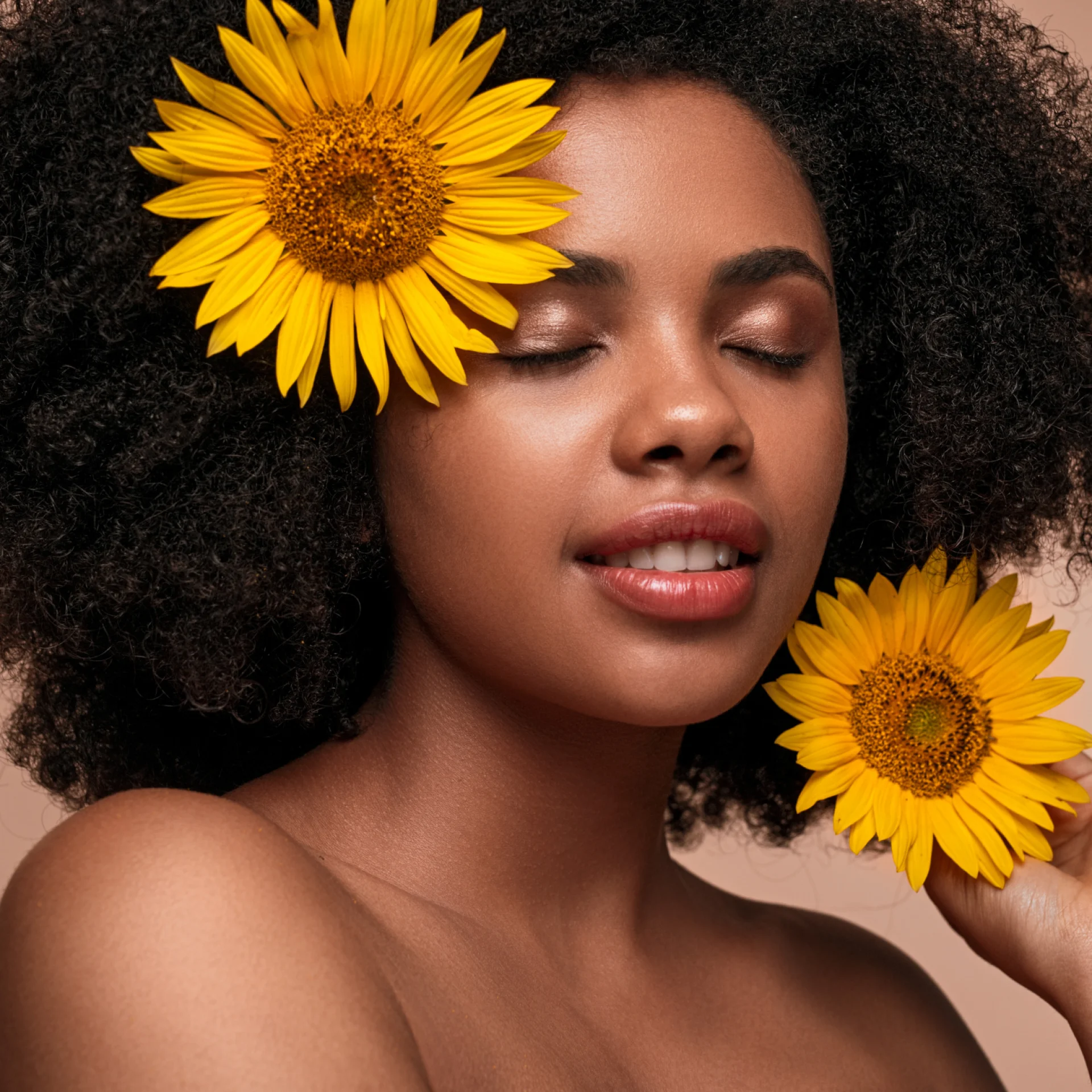 Mulher com os olhos fechado com o duas flores girassois atrás da orelha
