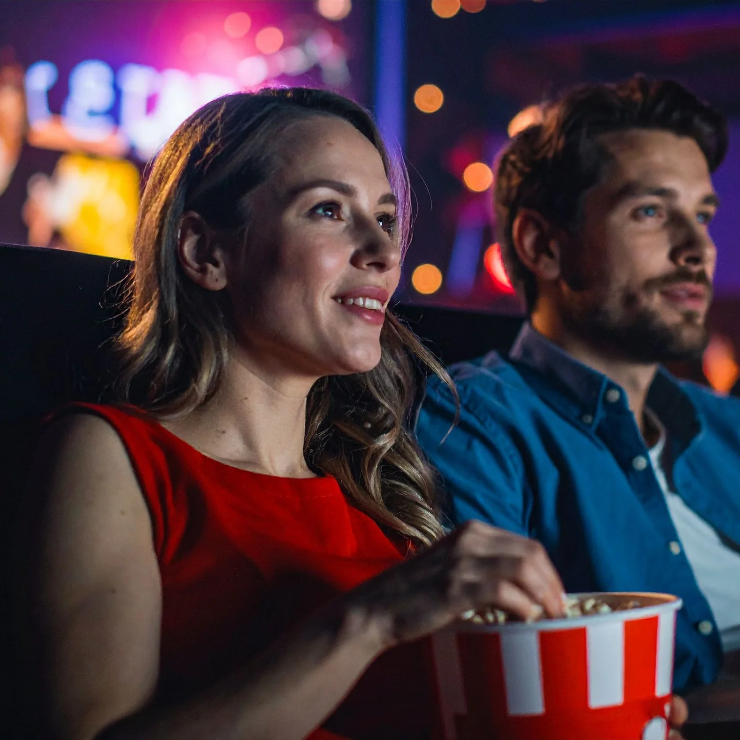 Uma mulher e um homem na sala de cinema comendo pipoca