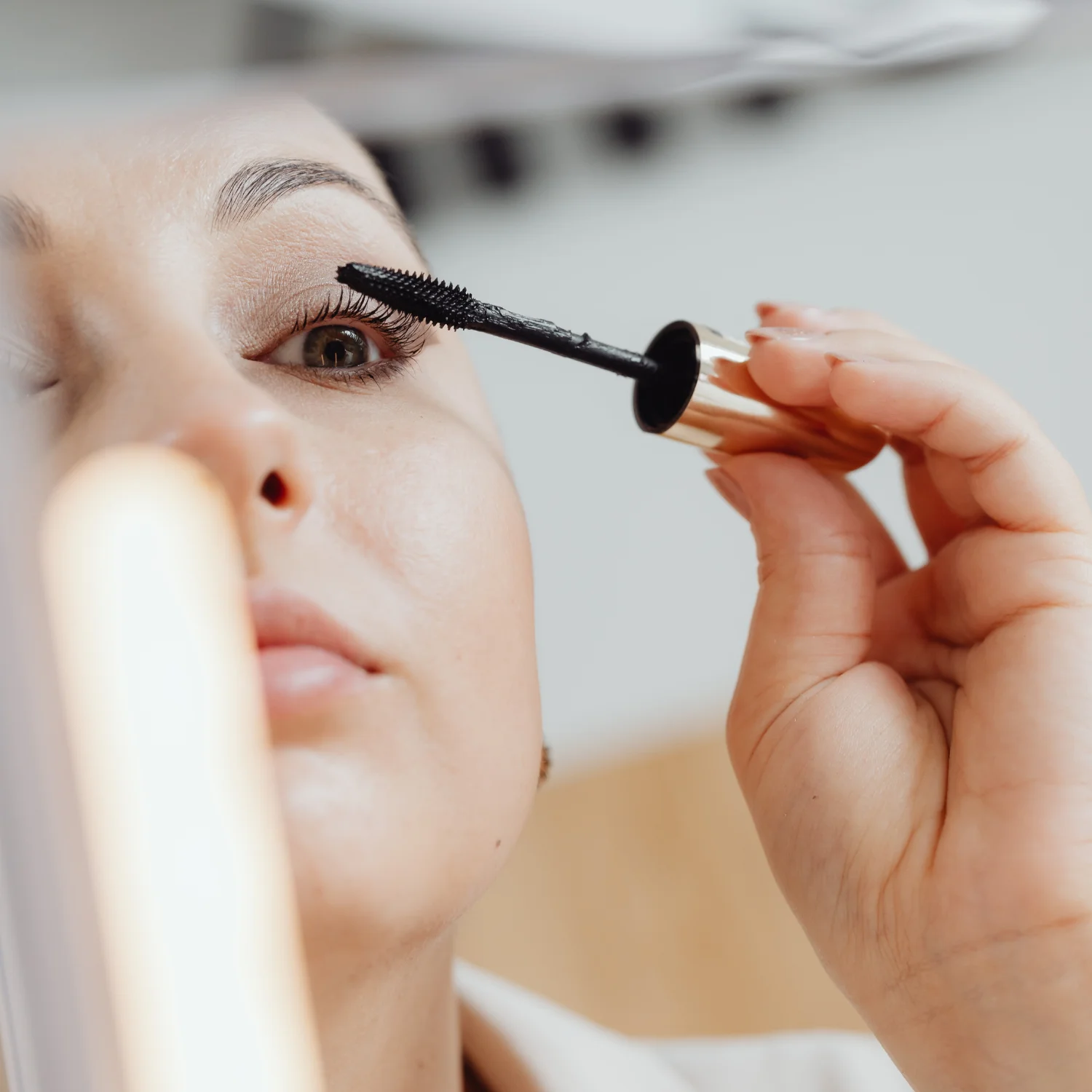 Mulher passando rímel nos olhos